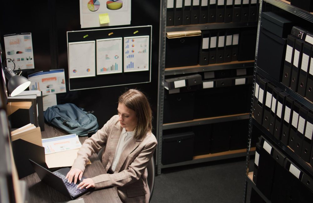 Especialista organizando expedientes en un archivo institucional